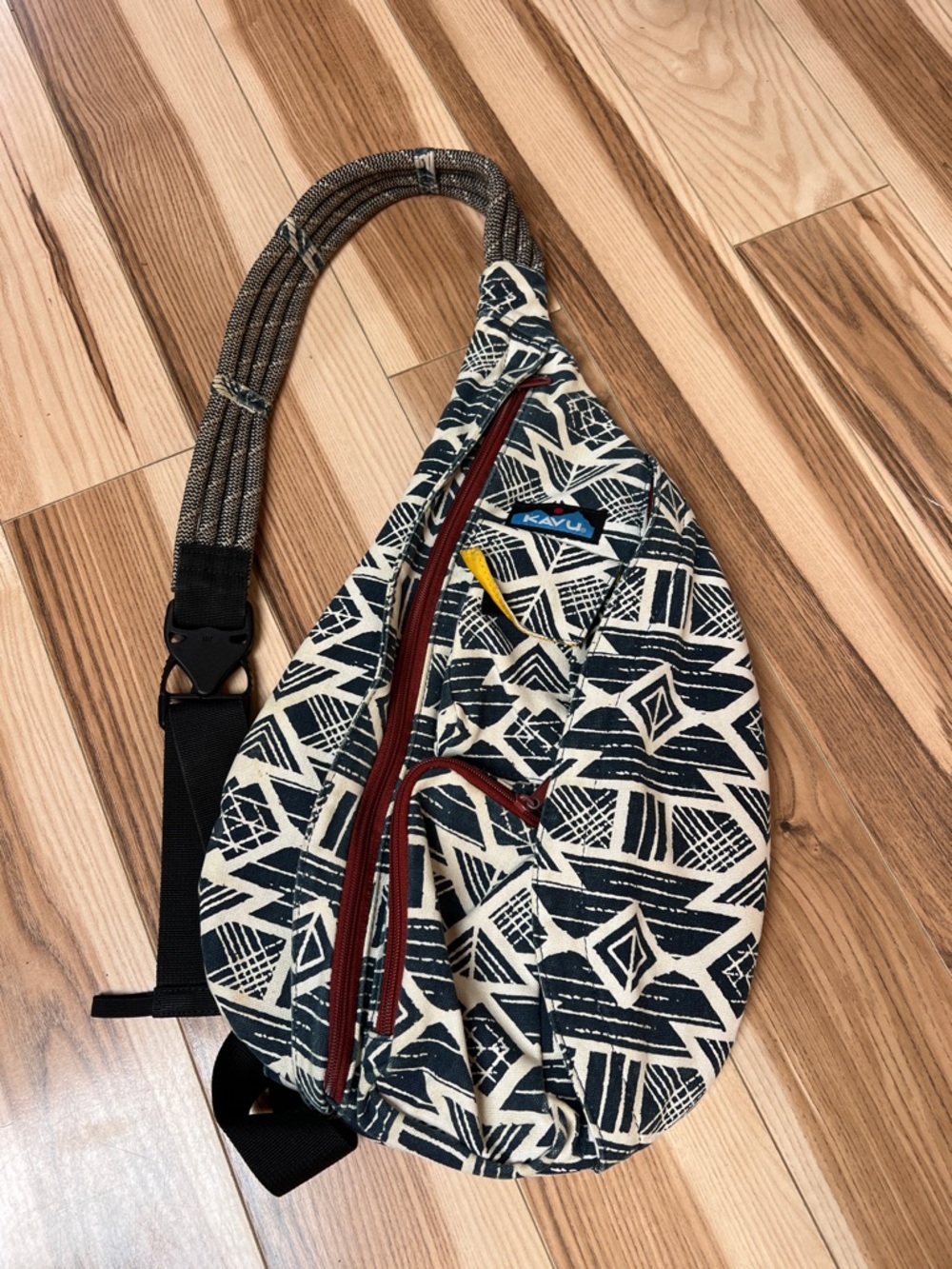 KAVU Rope Sling bag in a blue and white geometric pattern with red zipper
